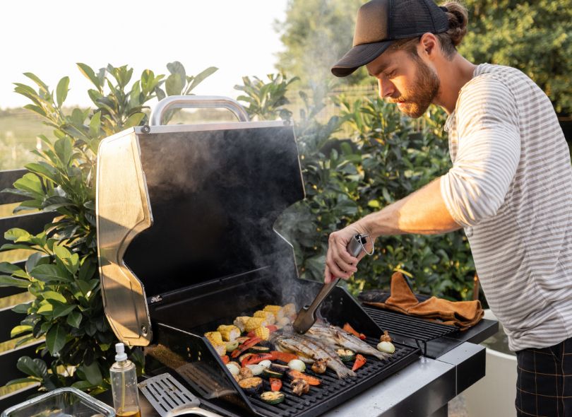Man cooking food on a BBQ.