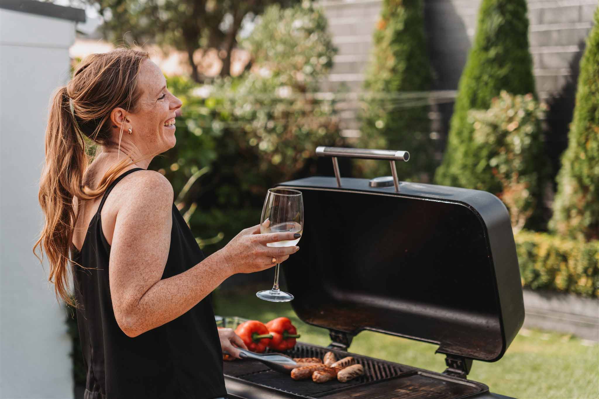 woman cooking on gas BBQ